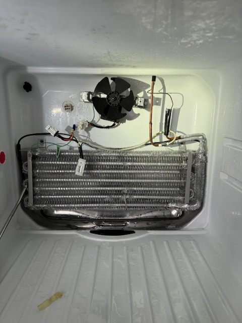 The same evaporator coil cleared of ice and working normally after repair