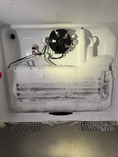 Refrigerator evaporator coil completely encased in ice, blocking airflow