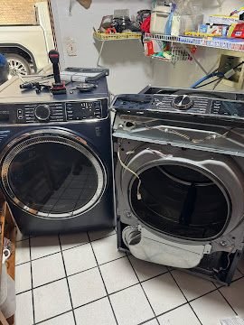 Front-load washer beside a partially disassembled dryer during a repair
